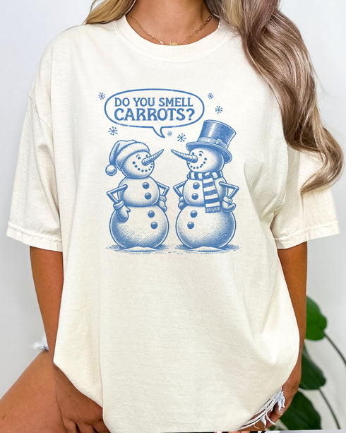 Woman wearing retro snowman shirt in natural beige color with the quote "Do You Smell Carrots?"
