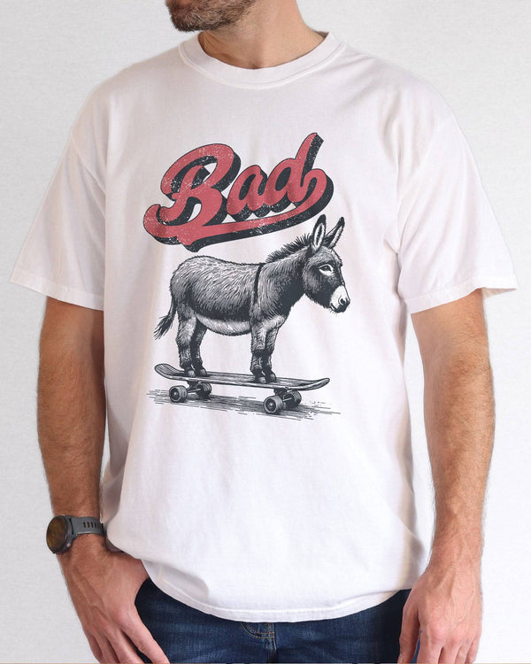 Model wearing white color shirt with 'Bad Donkey Riding A Skateboard' graphic design
