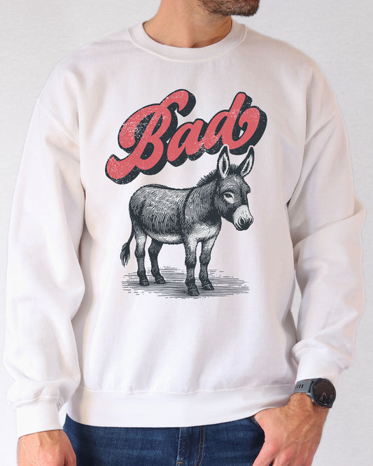 Man wearing a white unisex retro donkey sweatshirt with the word 'Bad' above the graphic.