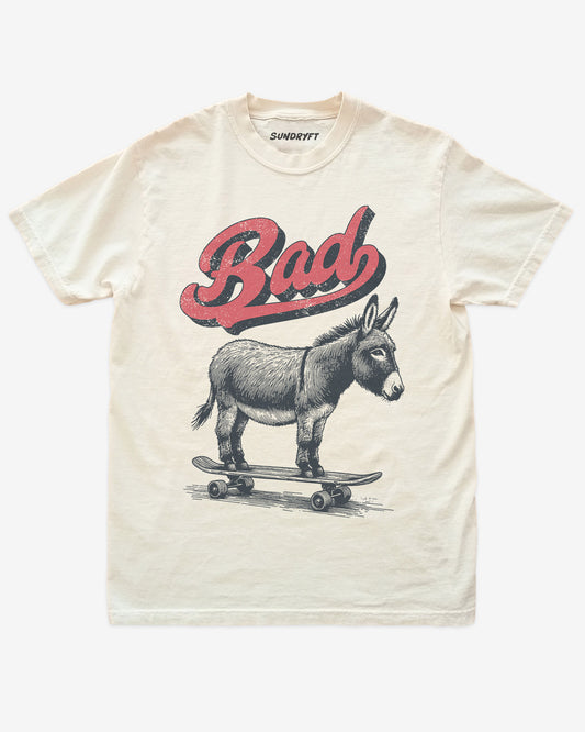 Ivory “Badass Donkey On Skateboard” funny retro skate pun shirt flat lay.