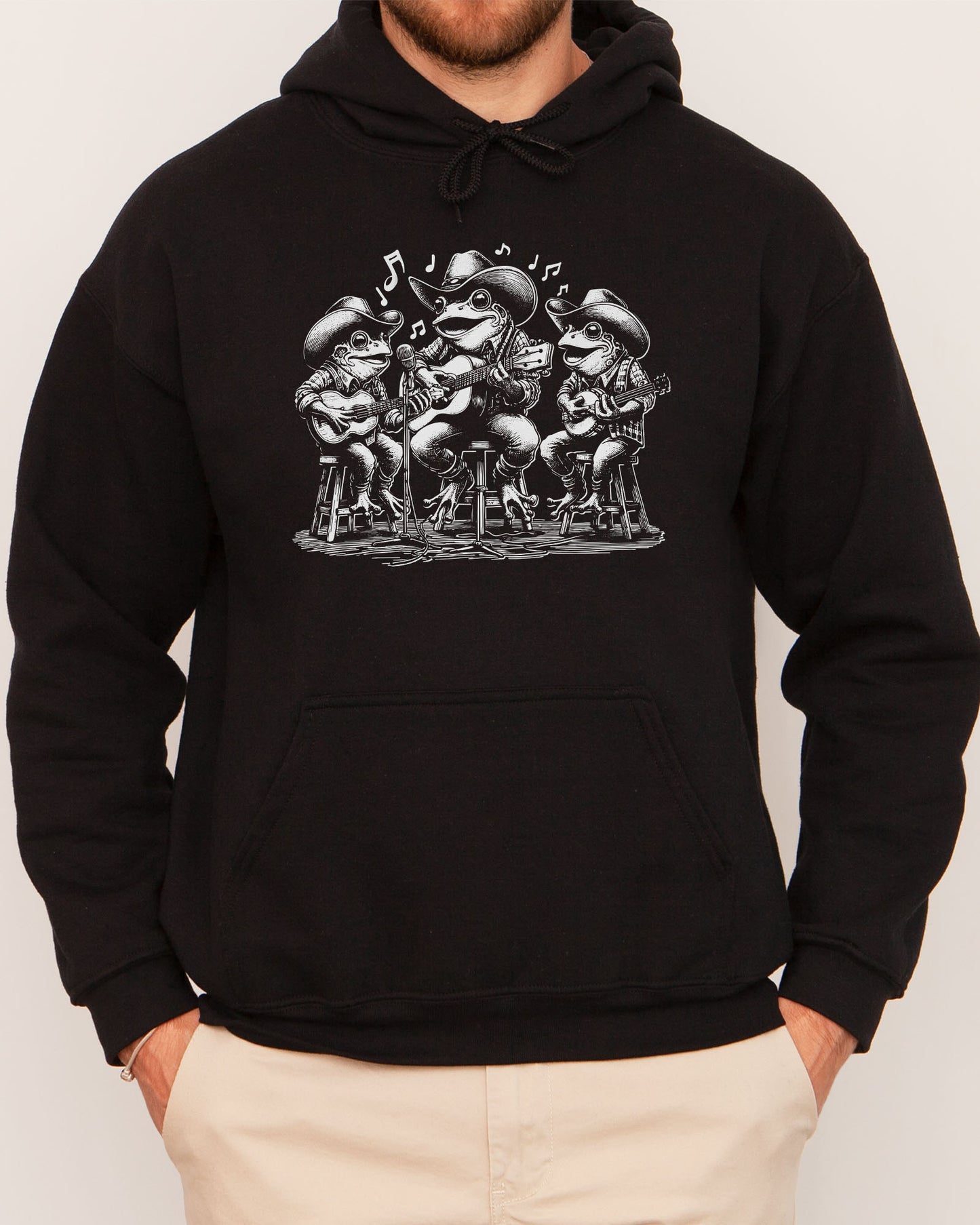 Man wearing black-colored hoodie featuring a funny retro country frog band graphic.