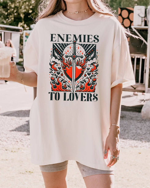 Woman wearing ivory color "Enemies To Lovers" shirt with retro medieval romantic graphic.
