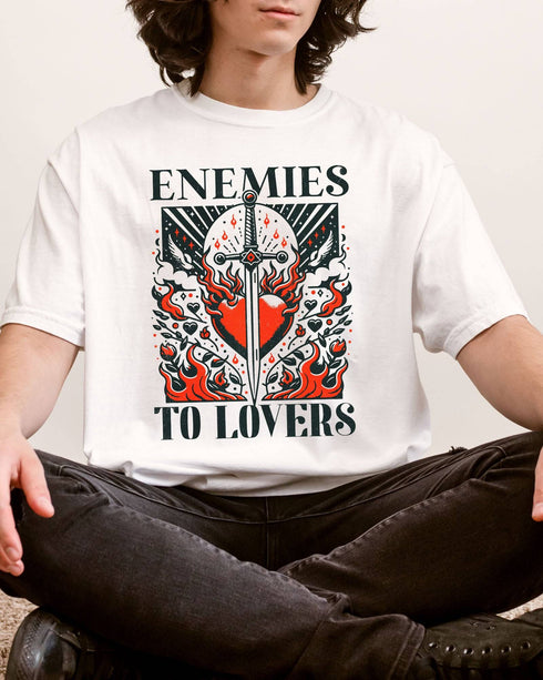Man wearing white color "Enemies To Lovers" shirt with retro medieval romantic graphic.