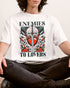Man wearing white color "Enemies To Lovers" shirt with retro medieval romantic graphic.