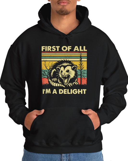 Man wearing a 'First of All I'm A Delight' hoodie in black, featuring a retro western graphic design and unisex fit.