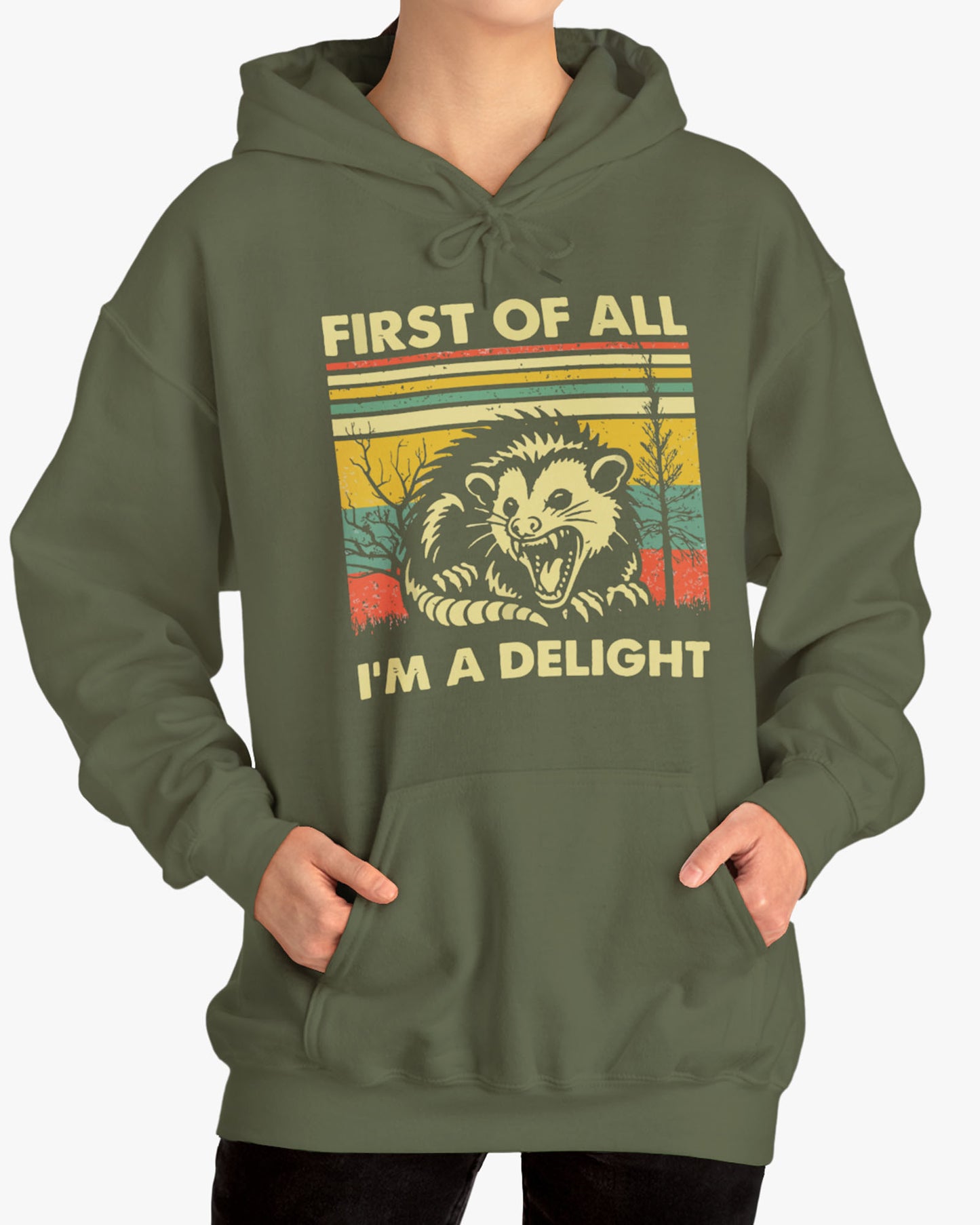 Woman wearing a 'First of All I'm A Delight' hoodie in military green, featuring a retro western graphic design and unisex fit.