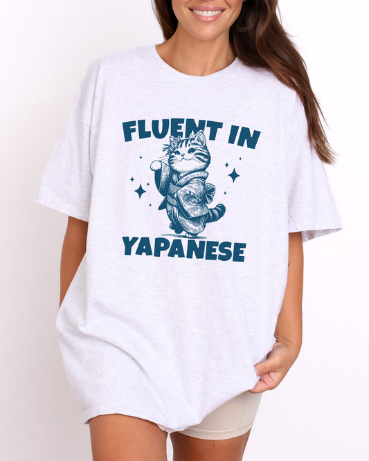 Model wearing ash color shirt with 'Fluent In Yapanese' japanese cat graphic design