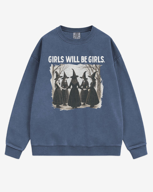 Flat lay denim 'Girls Will Be Girls' sweatshirt with retro graphic of witches holding hands in a Halloween ritual.
