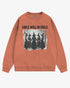 Flat lay terracotta 'Girls Will Be Girls' sweatshirt with retro graphic of witches holding hands in a Halloween ritual.