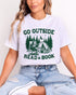 Model wearing ash color shirt with 'Go Outside Read A Book' graphic design