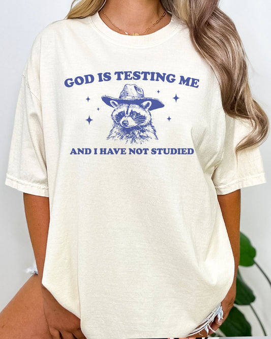 Woman wearing God Is Testing Me And I Have Not Studied shirt in natural beige color