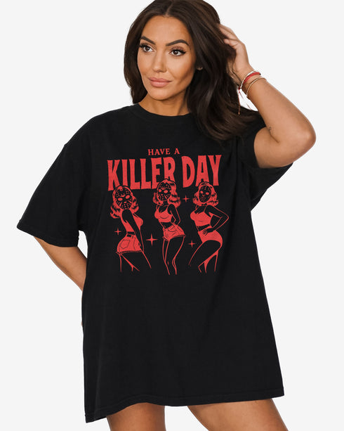 Woman wearing a black “Have A Killer Day” shirt with a funny Halloween graphic of bikini girls in hockey masks.