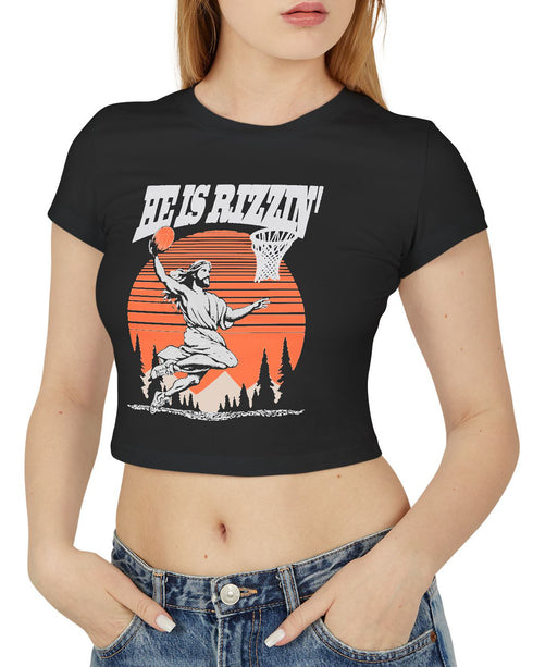 Woman wearing a black 'He Is Rizzin' baby tee featuring a funny retro Jesus playing basketball graphic, perfect for Y2K and Christian humor style.