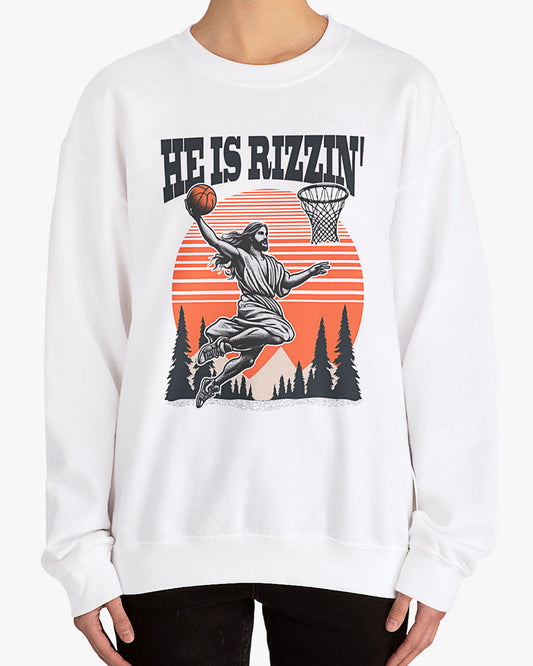 Woman wearing white 'He Is Rizzin' sweatshirt with retro Jesus dunking basketball graphic, perfect for Easter and funny Y2K style.
