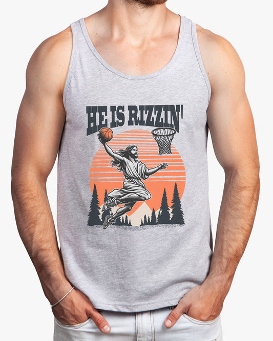 Man wearing 'He Is Rizzin' tank top in athletic heather featuring a funny retro graphic of Jesus dunking a basketball, perfect for summer style and humor.