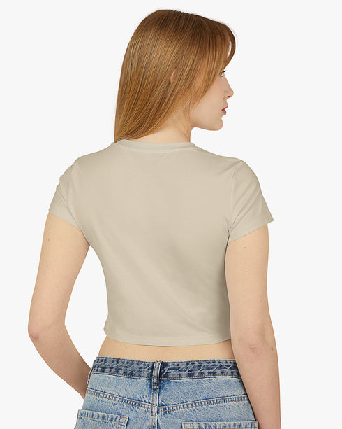 Back view of woman wearing a sand beige baby tee