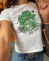 Woman wearing Howdy Go Lucky baby tee in white, retro Y2K cropped shirt with disco ball and cowboy hat graphic, funny Western St. Patrick’s Day style.