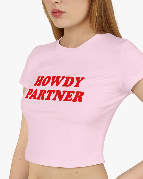 Woman wearing light pink 'Howdy Partner' baby tee
