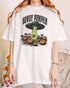 Woman wearing a white "Howdy Pumpkin" shirt with a retro graphic of a UFO abducting pumpkins from a field.