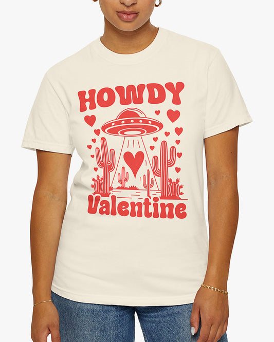 Woman wearing a natural 'Howdy Valentine' shirt featuring a funny retro western landscape graphic with a UFO