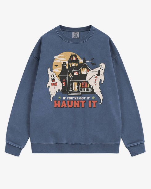 Flat lay denim sweatshirt with phrase ‘If You’ve Got It Haunt It’ and retro graphic of two ghosts and a haunted house.