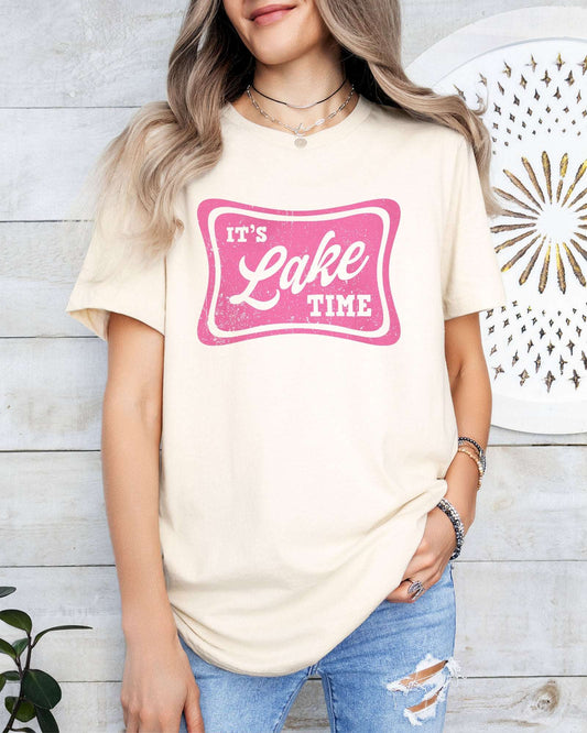 Model wearing natural color shirt with 'It's Lake Time' graphic design