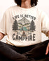 Close-up of man wearing 'Life Is Better By The Campfire' shirt in ivory color and with retro camping nature graphic