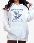 Woman wearing white 'Live Laugh Lobotomy' hoodies with funny retro graphic of armor flying on a rocket.