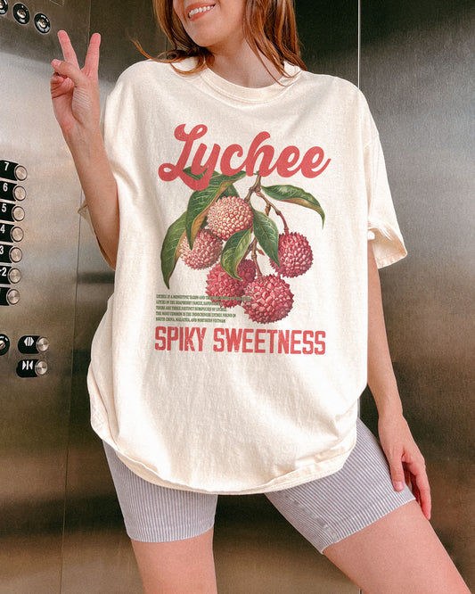 Woman wearing an ivory-colored Lychee retro graphic shirt.