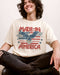 Man wearing "Made In America 1776" shirt in ivory color with retro graphic of a hawk in USA red-white-and-blue colors.
