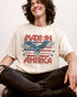 Man wearing "Made In America 1776" shirt in ivory color with retro graphic of a hawk in USA red-white-and-blue colors.