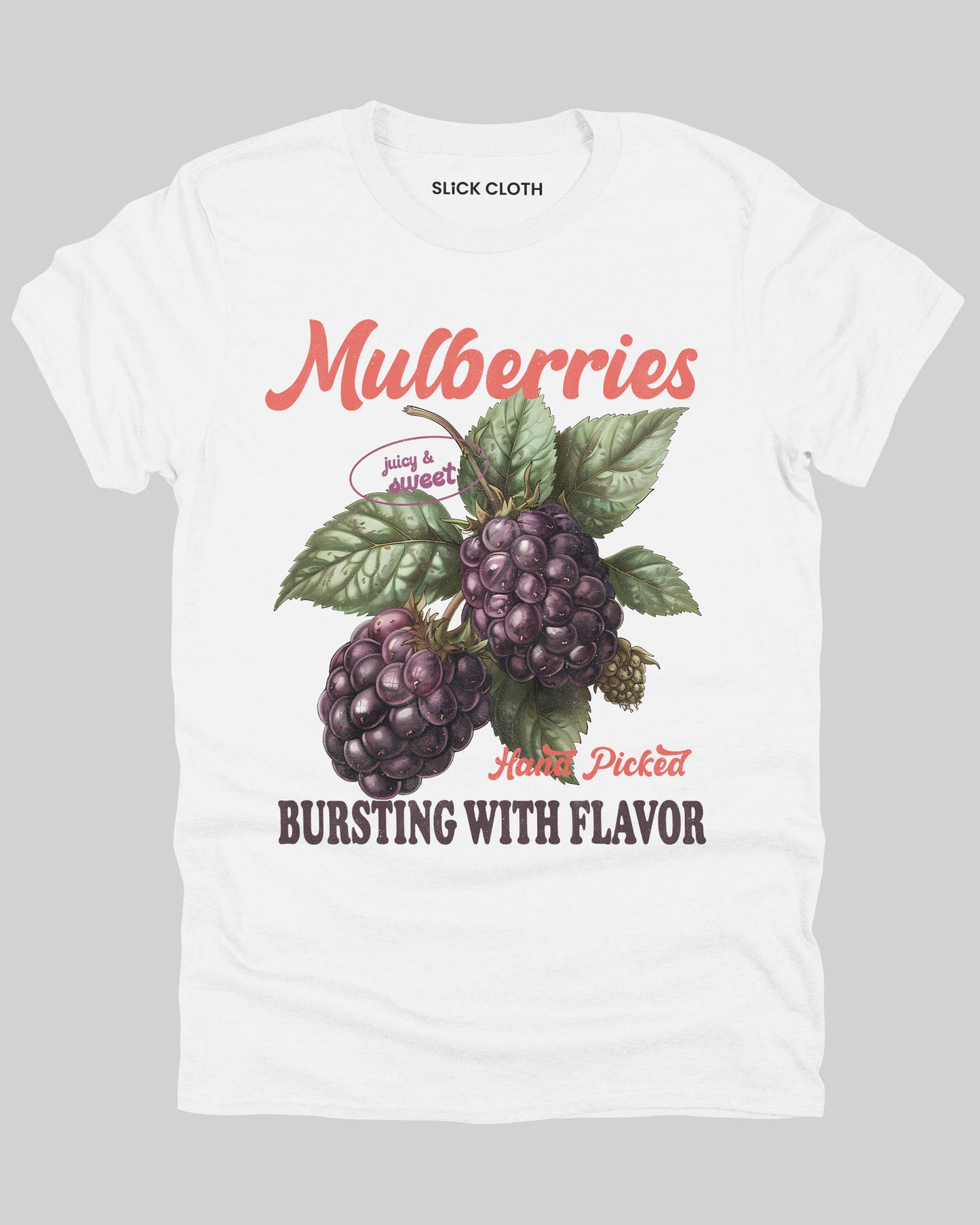 Flat lay of a white-colored t-shirt featuring a retro fruit graphic with the quote 'Mulberries - Bursting With Flavor.'