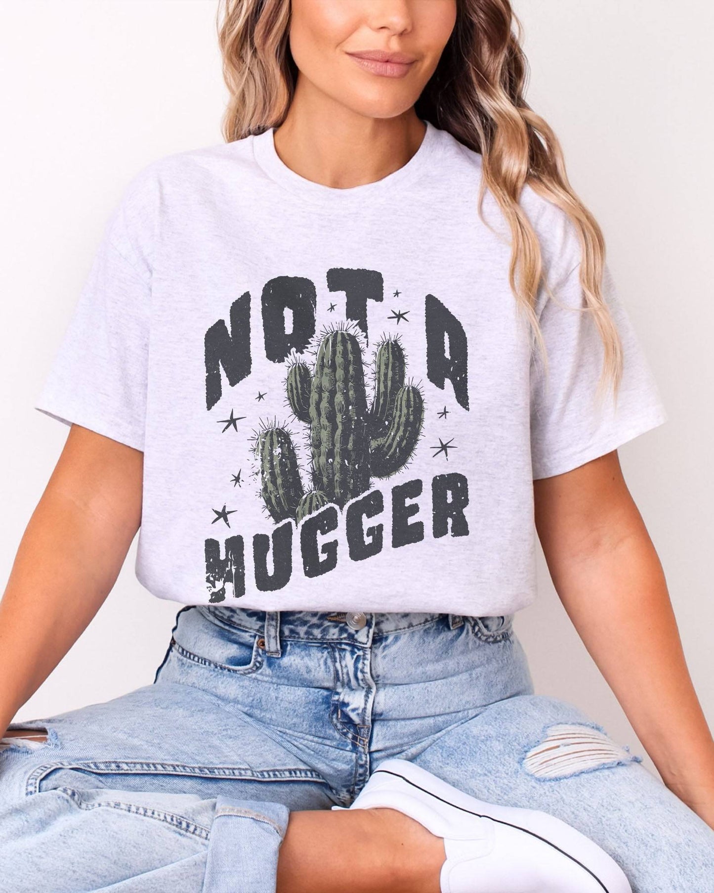 Model wearing ash color shirt with 'Not A Hugger' cactus graphic design