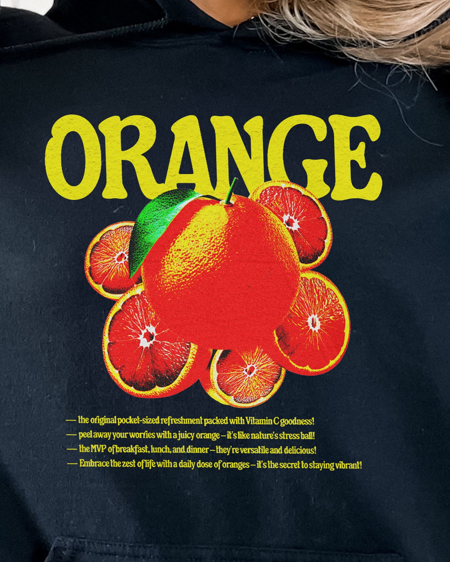 Close-up of a black hoodie featuring a retro orange fruit graphic.