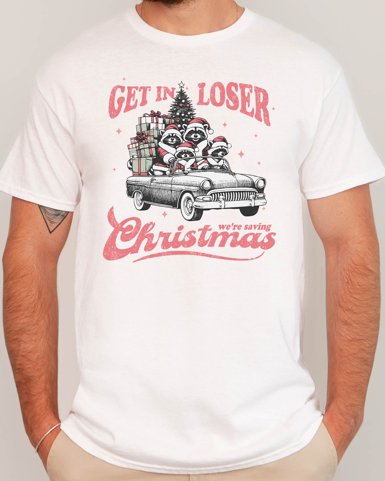 Man wearing "Get In Loser We're Saving Christmas" shirt in white color with a retro funny raccoon XMAS graphic