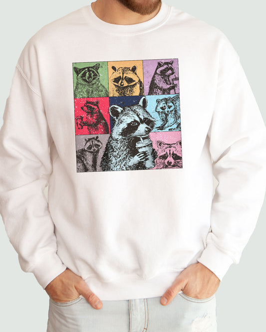 Man wearing a sweatshirt in white, featuring a retro raccoons drinking coffee collage graphic design and unisex fit.