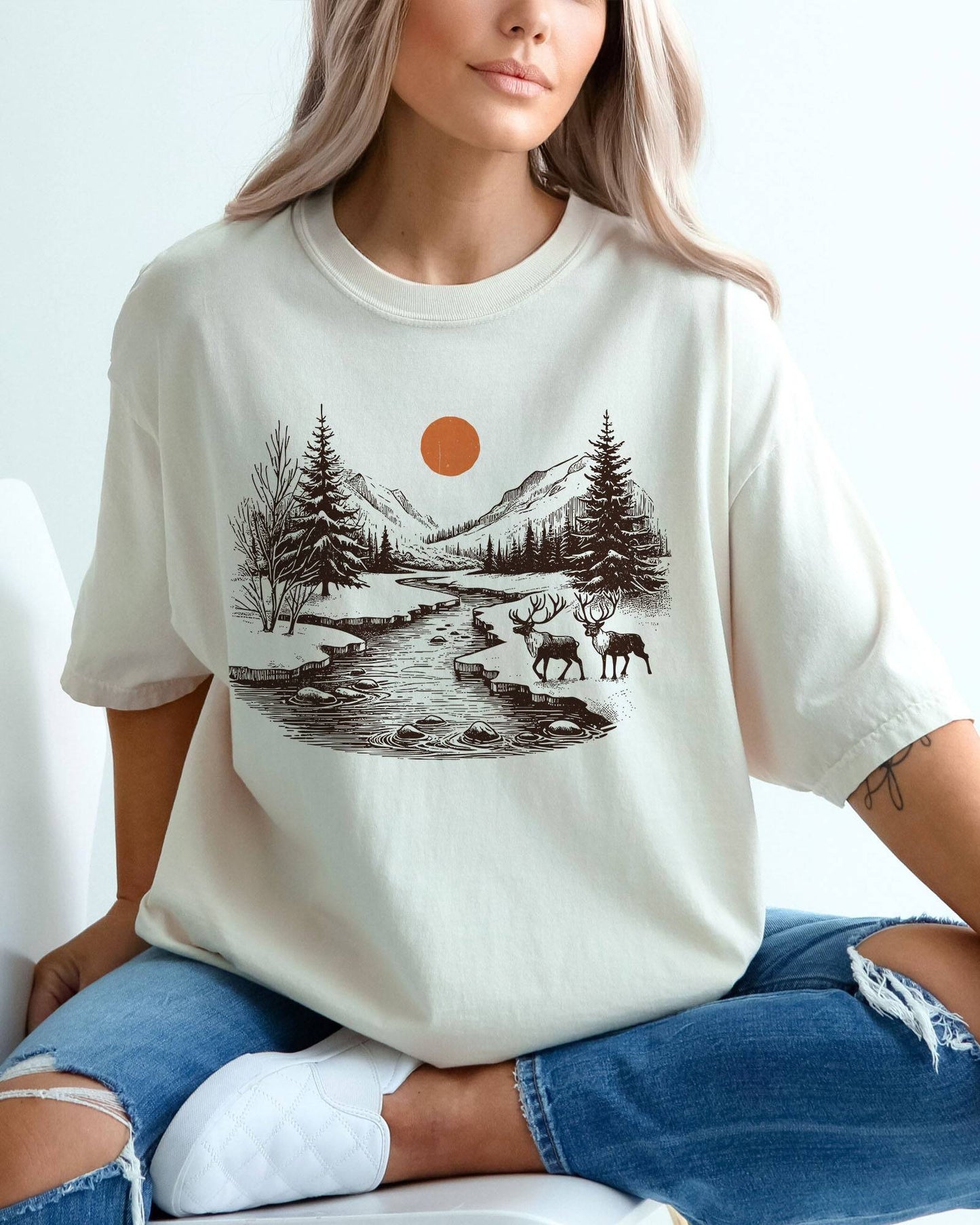 Model wearing ivory color shirt with reindeer nature retro graphic design