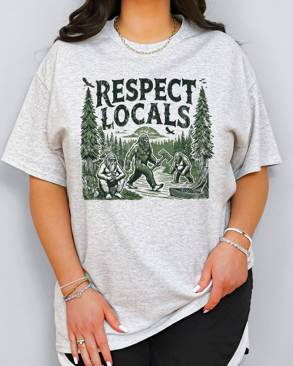 Model wearing ash color shirt with 'Respect Locals' Bigfoot graphic design