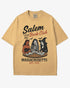 Flat lay mustard-colored 'Salem Book Club Massachusetts 1692' shirt with retro Halloween graphic of a devil, skeleton, and witch sitting together reading at a table.