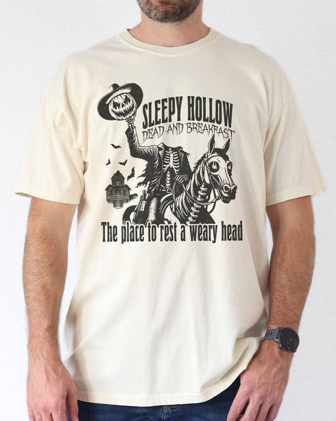 Model wearing ivory color shirt with 'Sleepy Hollow Dead And Breakfast - The Place To Rest A Weary Head' graphic design