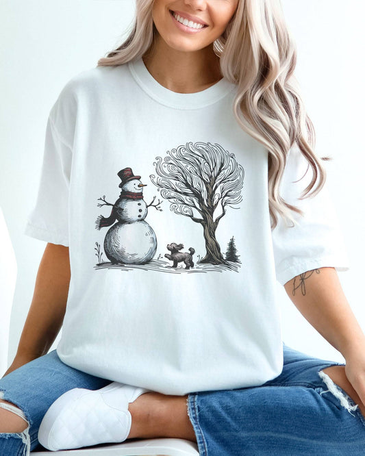 Model wearing white color shirt with snowman and og winter landscape graphic design