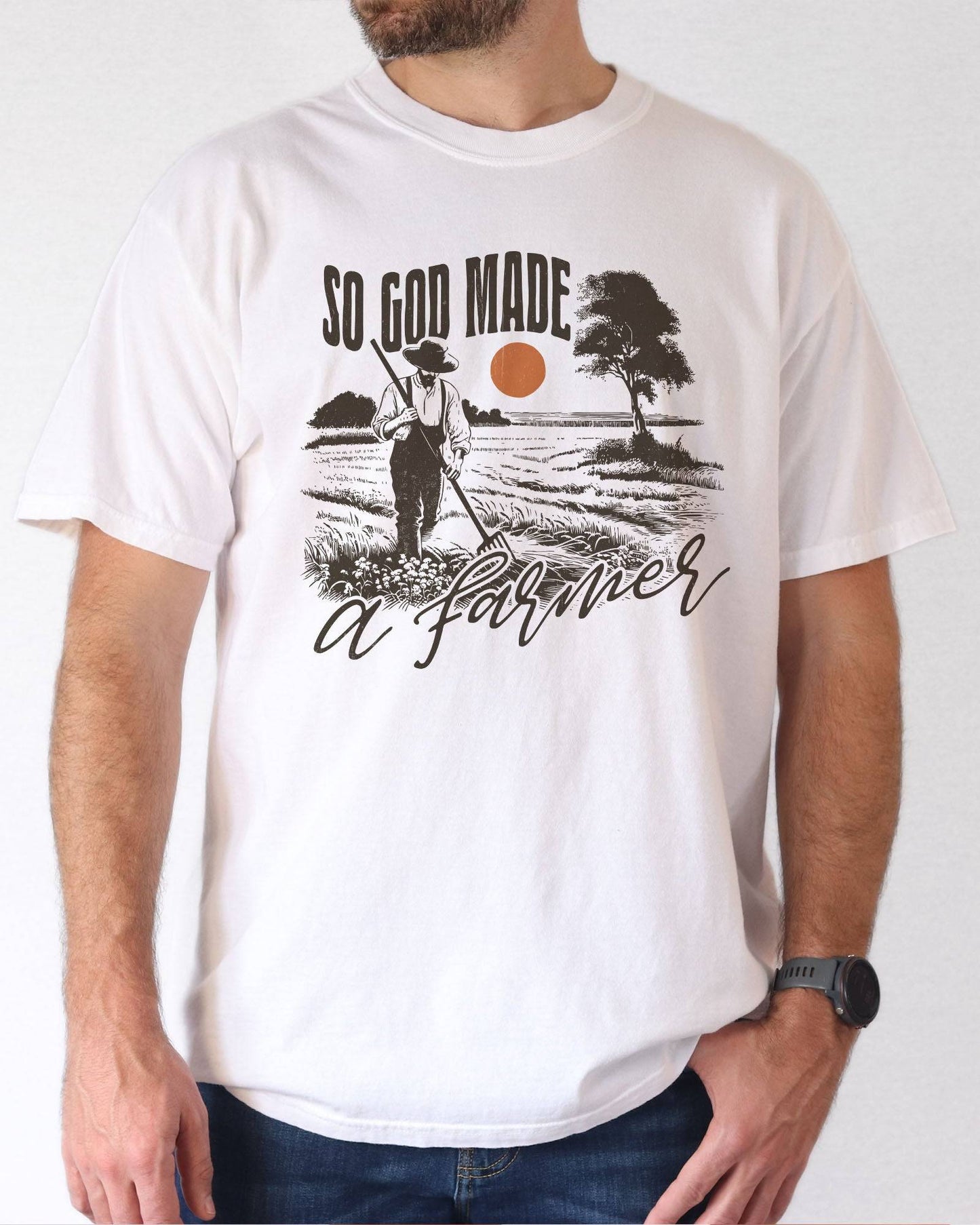 Model wearing white color shirt with 'So God Made A Farmer' graphic design