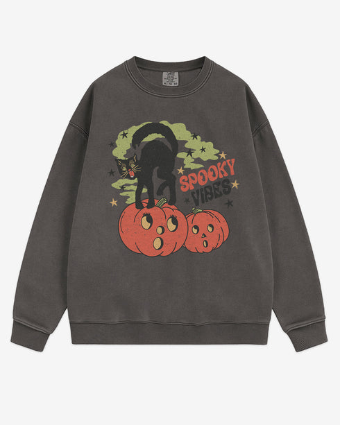 Flat lay pepper Halloween sweatshirt reading โSpooky Vibesโ with retro graphic of black cat standing on pumpkins.