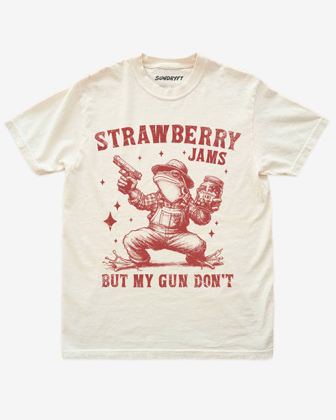 Strawberry Jams But My Gun Don't shirt in ivory with funny frog holding a jar of strawberry jam and a gun graphic