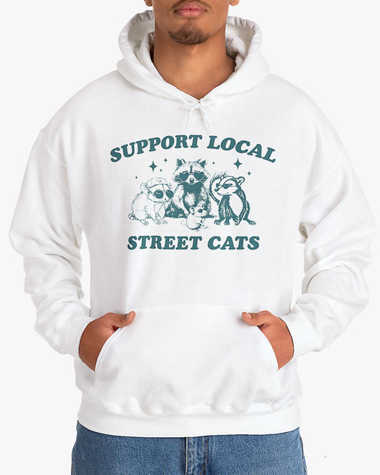 Man wearing white 'Support Local Street Cats' hoodie with funny retro raccoon and opossum graphic