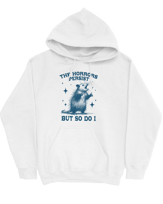 Flat lay of a white 'The Horrors Persist But So Do I' hoodie featuring a funny retro yelling opossum graphic.