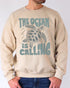 Model wearing sand color sweatshirt with 'The Ocean Is Calling' graphic design