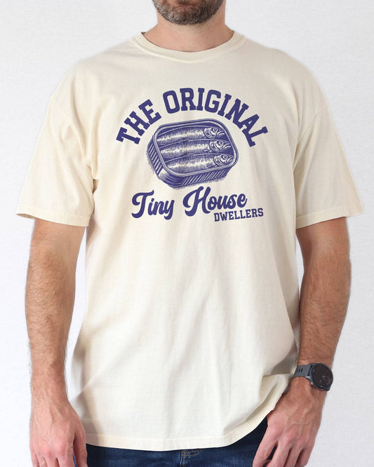 Man wearing an ivory "The Original Tiny House Dwellers" shirt featuring a retro graphic of sardines packed in a tin can.