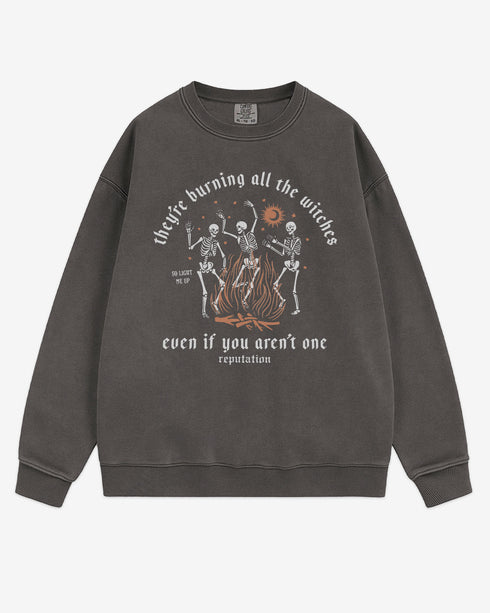 They’re Burning All The Witches Sweatshirt flat lay pepper color retro graphic with skeletons dancing in fire