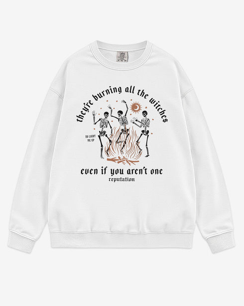 They’re Burning All The Witches Sweatshirt flat lay white color retro graphic with skeletons dancing in fire